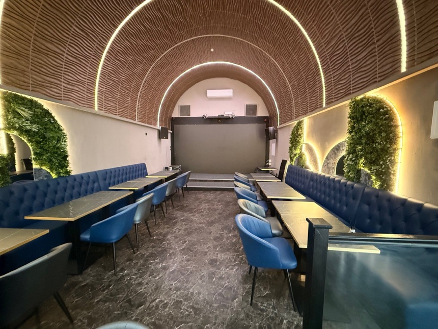 Refurbished bar with timber-slatted vaulted ceiling and banquette seating
