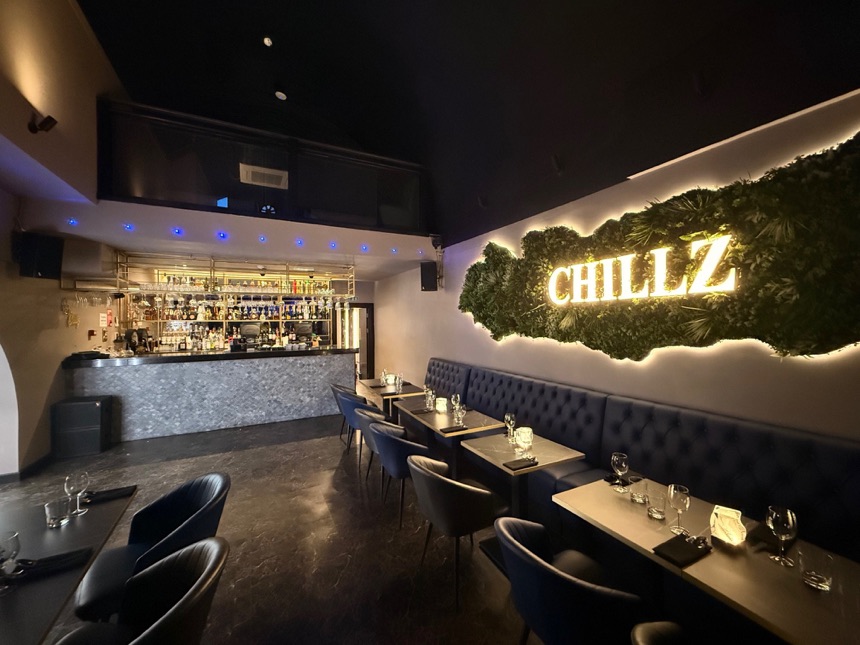 Refurbished bar with illuminated feature wall and blue banquette seating