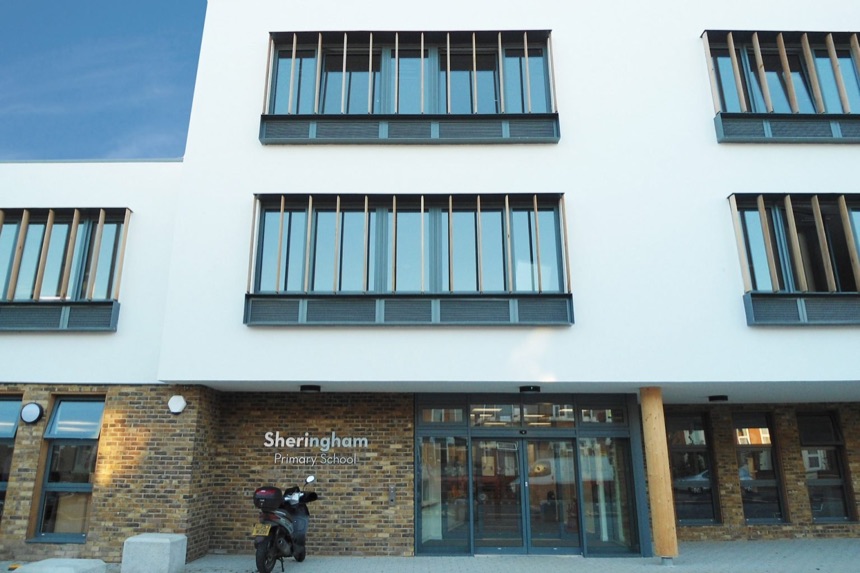 Exterior of a school building with large windows and ground-floor entrances