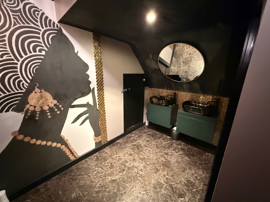 Refurbished washroom with statement mural, mirror and vanity units